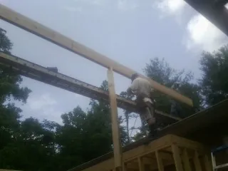 Carpenter setting a ridge beam over a new addition frame — Ice Dam Removal by Roofing Brothers in Mystic