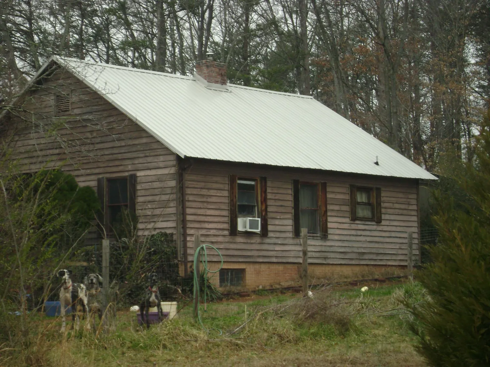 White metal roof on an old wood sided farmhouse, from a Metal Roof Installation job in Mystic